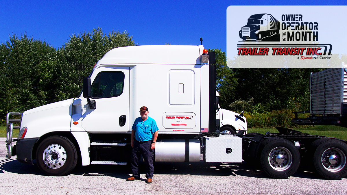 Trailer Transit Inc. | Owner Operator of the Month of July, Terry, stands in front of his white semi-truck. The top right corner displays "Owner Operator of the Month" alongside the "Trailer Transit Inc." logo. Trees are visible in the background, highlighting the prestige of owner operator driving jobs.