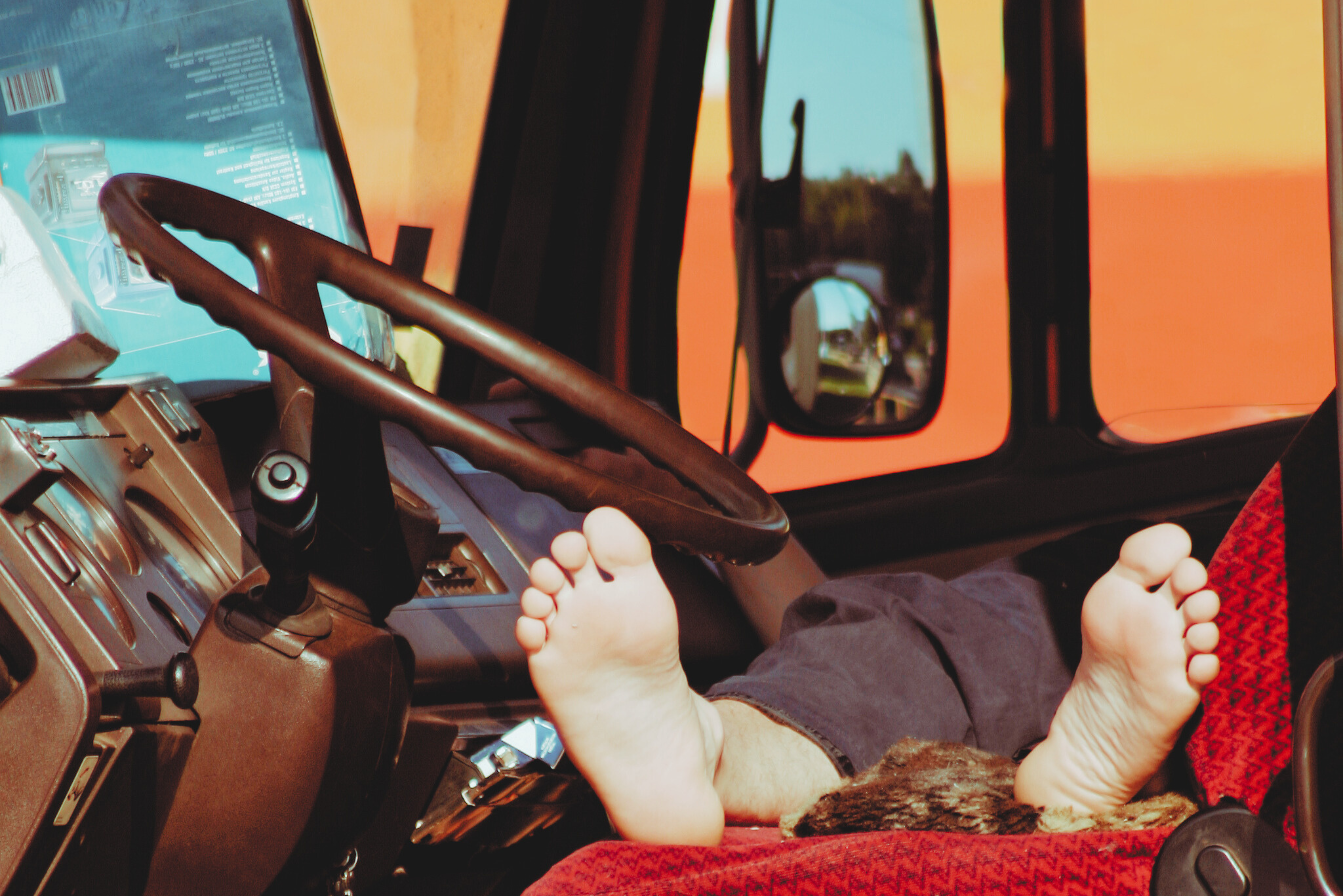 Trailer Transit, Inc | feet of man sleeping in the cab of his semi truck