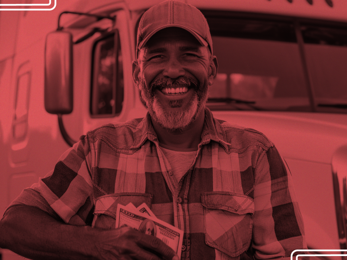 Trailer Transit Inc. | Man in a plaid shirt and cap, grinning in front of his truck, clutches cash to show that being an owner operator truck driver has helped his finances.